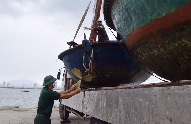 Bộ đội Biên phòng giúp ngư dân đưa thuyền, thúng máy lên bờ bảo đảm an toàn. Ảnh: Hoàng Hiệp