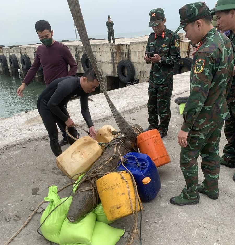 Lực lượng chức năng Quảng Bình trục vớt quả bom lên bờ, vận chuyển đến khu vực an toàn. (Ảnh: Thành Tiến).