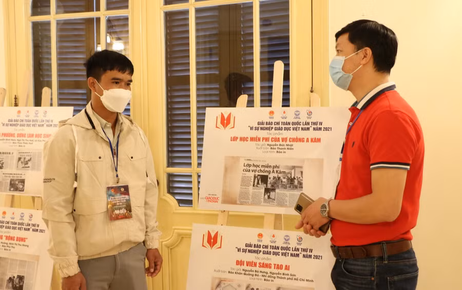 Thầy A Kâm (bên trái) trao đổi với phóng viên Báo Giáo dục &amp; Thời đại