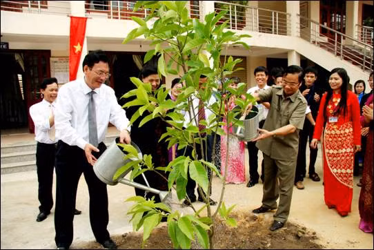 Phó Chủ tịch Quốc hội Tòng Thị Phóng, Bộ trưởng Bộ GD&ĐT Phạm Vũ Luận và các đại biểu trồng cây lưu niệm tại sân trường. Ảnh: Nguyễn Lâm