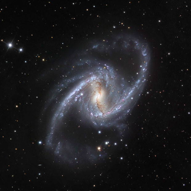 The NGC 1365 galaxy, also known as the Great Barred Spiral Galaxy, is seen in an image that combines observations performed through three different filters with the 1.5-metre Danish telescope at the European Southern Observatory (ESO) in Chile. The ESO’s website describes the galaxy, at 60 million light-years from Earth, 200,000 light-years across and about twice the size of the Milky Way, as one of the largest known to astronomers