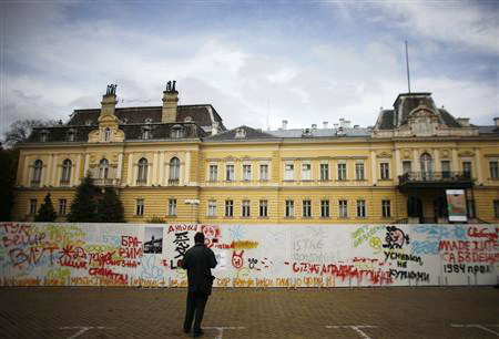 Một người đứng trước biểu tượng nghệ thuật của bức tường Berlin