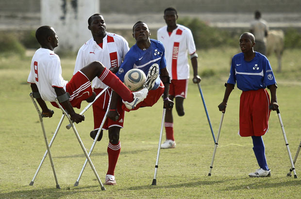 Những hình ảnh ấn tượng trong tuần ảnh 10 Haitian soccer players of the Zaryen team and the National amputee team fight for the ball during a friendly match in Port-au-Prince