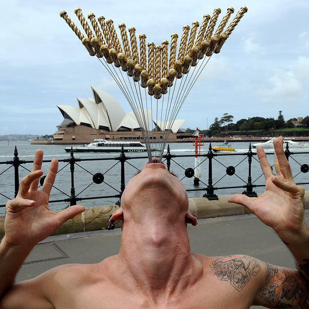 Chùm ảnh: Thế giới vui và lạ ảnh 8 A street performer named Chayne Hultgren (aka The Space Cowboy), re-enacts his 18-sword swallowing attempt for a Guinness World Record in front of the Sydney Opera House