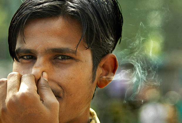 Chùm ảnh: Thế giới vui và lạ ảnh 9 A youth named Chaman demonstrates how he can blow cigarette smoke through his ears, in New Delhi, India