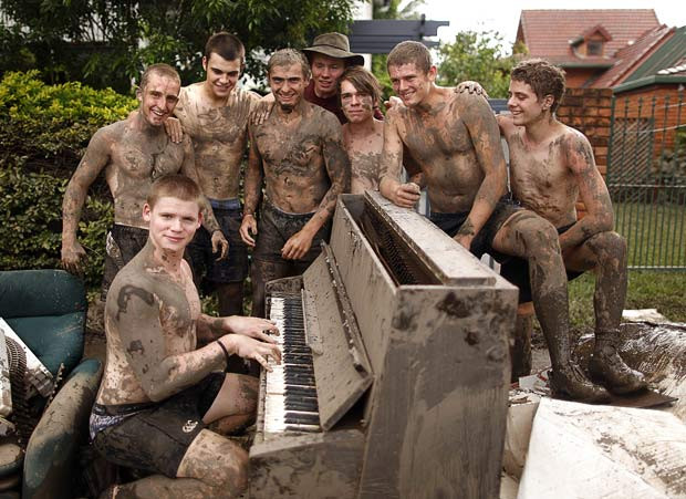 Những hình ảnh ấn tượng trong tuần ảnh 6 The mud covered friends of Andrew Taylor (2nd right) pose around a piano as they help his family clean their house after flood waters receded in the Brisbane suburb of Westend