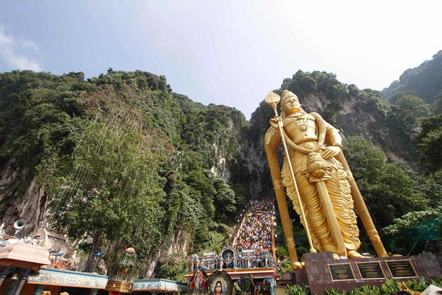 Hindu devotees climb the a 272-step staircase next to the giant statue of Lord Murugan to the Batu Caves temple to complete their pilgrimage during Thaipusam festival outside Kuala Lumpur 