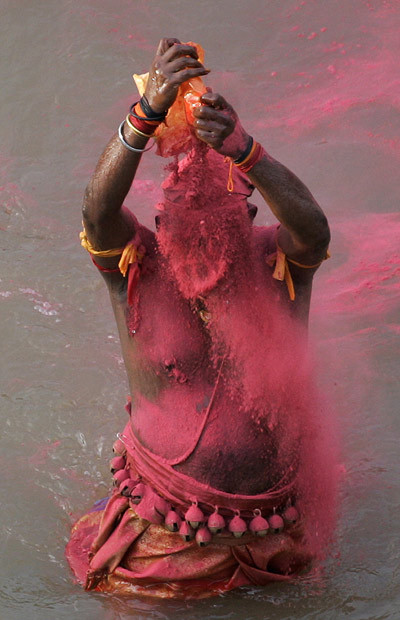 A Hindu devotee smears himself with red powder