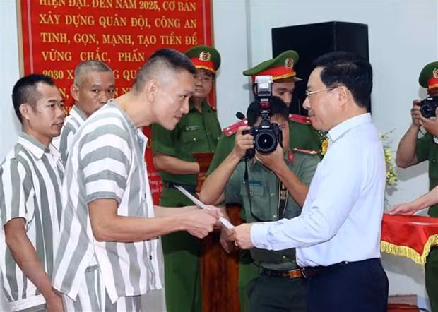 Phó Thủ tướng Thường trực Chính phủ Phạm Bình Minh trao quyết định đặc xá cho các phạm nhân. Ảnh: Phạm Kiên/TTXVN.