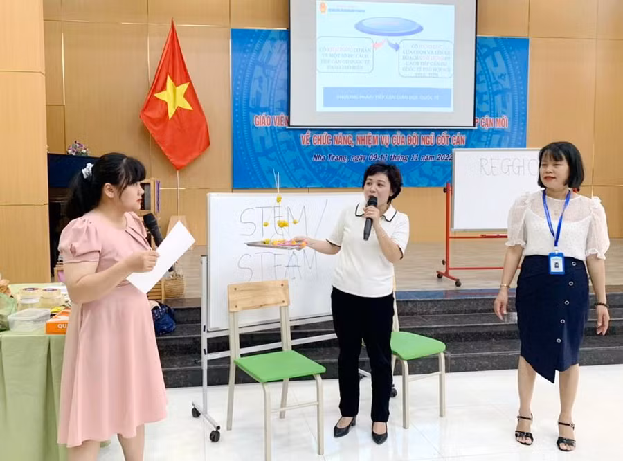 Bà Hoàng Thúy Hằng (ở giữa) trực tiếp làm báo cáo viên tại Khóa Tập huấn, bồi dưỡng giáo viên, cán bộ quản lý cốt cán mầm non dựa trên tiếp cận mới về chức năng và nhiệm vụ của đội ngũ cốt cán khu vực miền Trung.