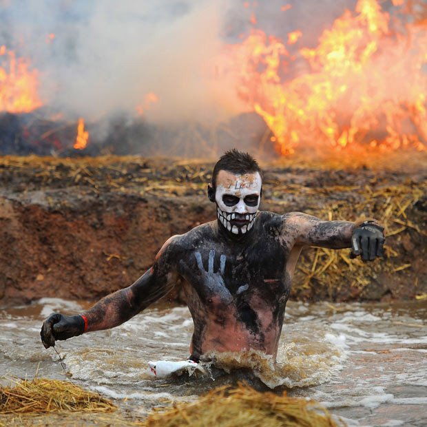 A competitor runs through water during the Tough Guy Challenge endurance race in Telford