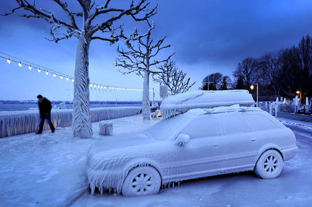 Những hình ảnh ấn tượng trong tuần ảnh 2 A man walks past an ice-covered car on the waterside promenade at Lake Geneva in Versoix, Switzerland