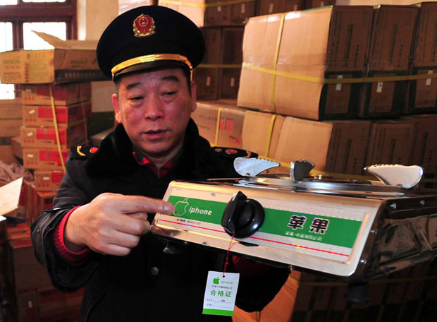 An official displays an ’iPhone’ gas burner in Wuhan, China. The single-ring stove carries Apple’s logo and the name of one of its best-known products. Industry and Commerce officials swooped on a consignment of 681 gas burners in Wuhan, Hubei Province, on Thursday.