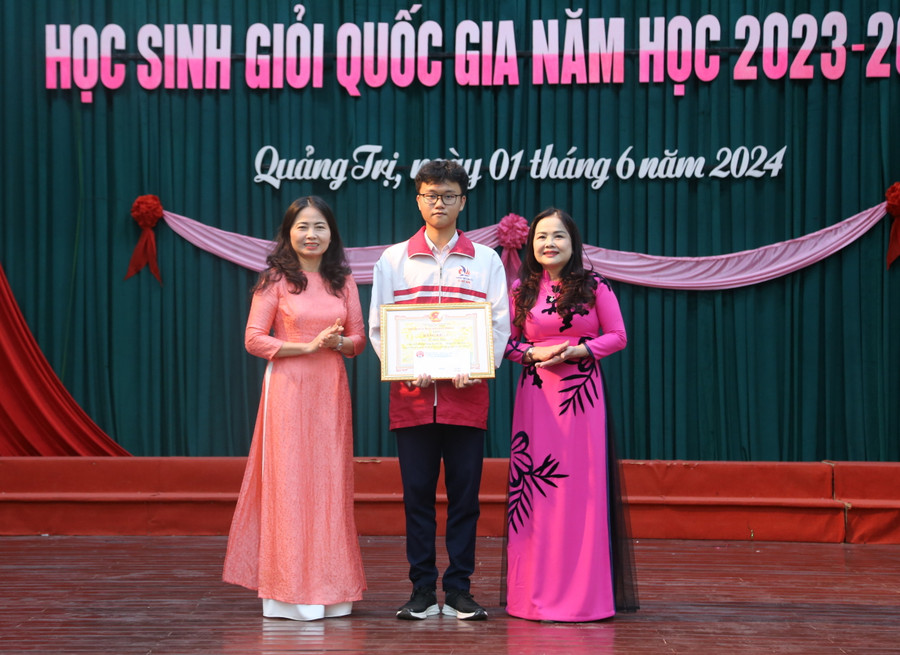 TS Lê Thị Hương, Giám đốc Sở GD&amp;ĐT Quảng Trị (bên phải) cùng bà Dương Thị Hải Yến, Chủ tịch Hội Khuyến học tỉnh (bên trái) trao Bằng khen của UBND tỉnh và khen thưởng cho em Lê Thiên Quân đạt giải Nhất môn Tin học.