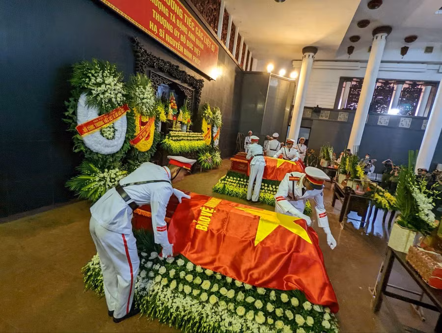 Nghi lễ phủ cờ lên áo quan các liệt sĩ được đội danh dự tiến hành trang nghiêm với sự có mặt của lãnh đạo Công an Hà Nội, các đơn vị, gia đình, người thân, đồng đội các liệt sĩ: thượng tá Đặng Anh Quân, thượng úy Đỗ Đức Việt và hạ sĩ Nguyễn Đình Phúc.