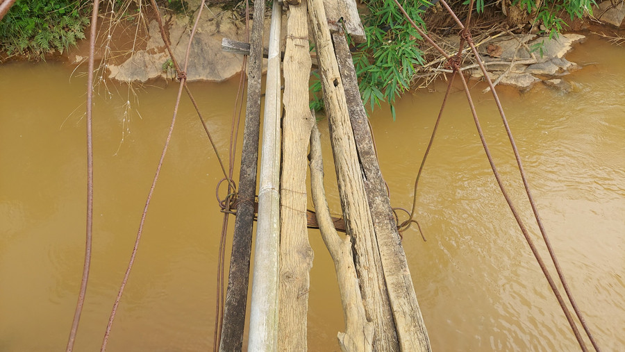 Trụ cầu được làm bằng gỗ, dây sắt hoen rỉ là thành cầu, còn thân cầu được chắp vá bằng những tấm ván cũ. Trụ cầu được làm bằng gỗ, dây sắt hoen rỉ là thành cầu, còn thân cầu được chắp vá bằng những tấm ván cũ.