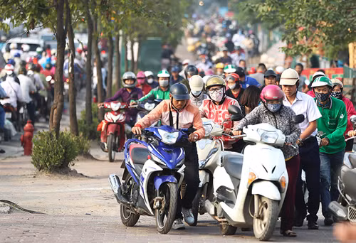 Người dân leo lên vỉa hè đường Lê Văn Lương đi ngược chiều. Ảnh: Ngọc Thành.