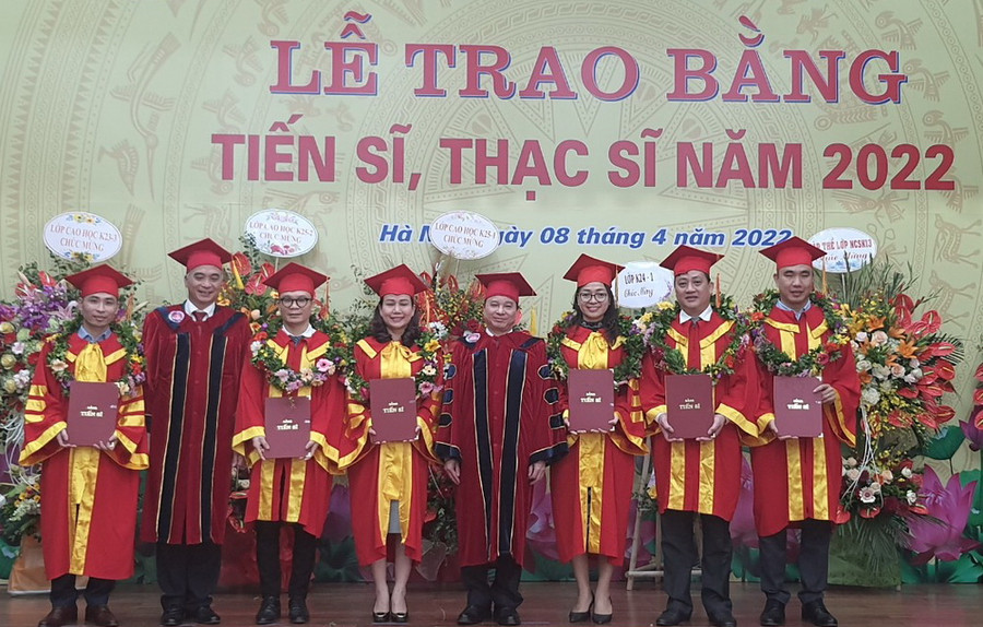 GS.TS Phạm Quang Trung - Giám đốc Học viện (thứ 4 từ phải qua trái) và PGS.TS Trần Hữu Hoan - Phó Giám đốc Học viện (thứ 2 từ trái qua phải) trao bằng tốt nghiệp và vòng nguyệt quế cho các tân tiến sĩ