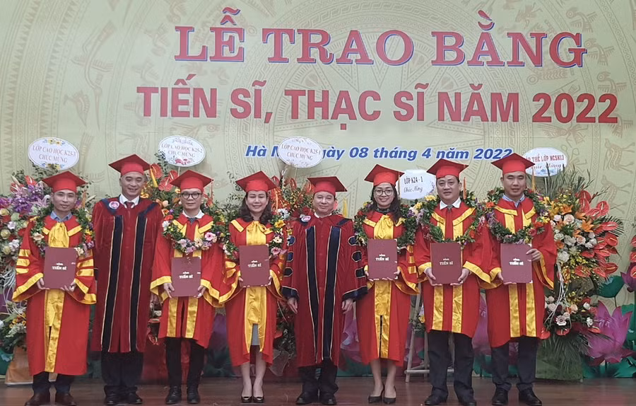 GS.TS Phạm Quang Trung - Giám đốc Học viện (thứ 4 từ phải qua trái) và PGS.TS Trần Hữu Hoan - Phó Giám đốc Học viện (thứ 2 từ trái qua phải) trao bằng tốt nghiệp và vòng nguyệt quế cho các tân tiến sĩ