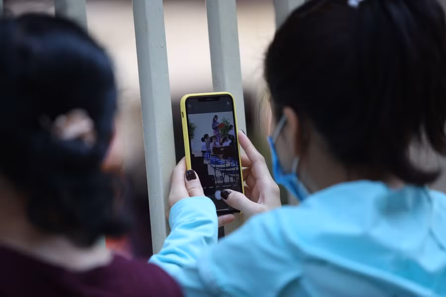 Phía bên ngoài, nhiều phụ huynh đợi và ghi lại những hình ảnh đầu tiên của con em mình khi bước chân vào lớp 1.