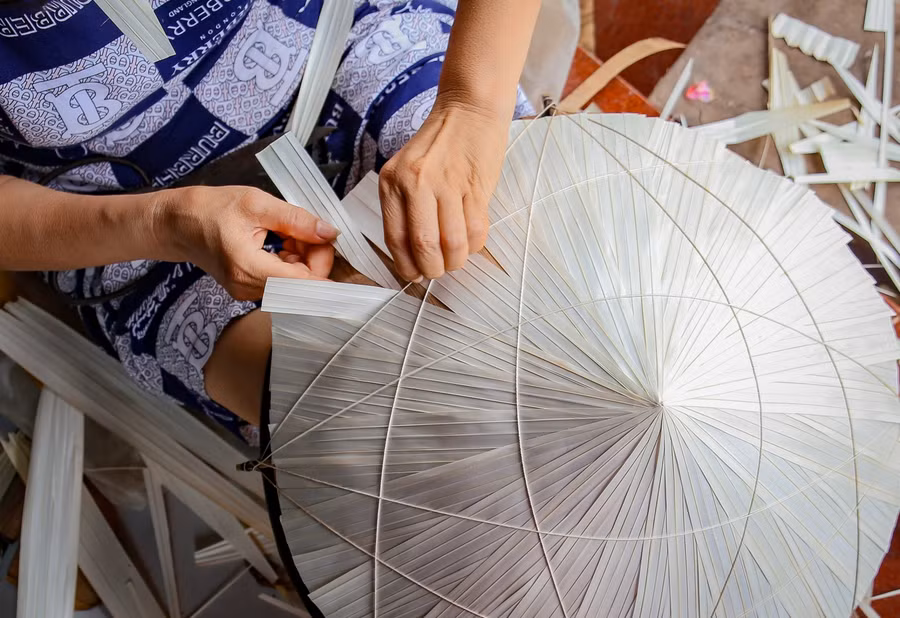 Lớp lá cuối cùng, được những người thợ tra tỉ mỉ, vì đây cũng chính là công đoạn quan trọng thể hiện hình dáng của chiếc nón.