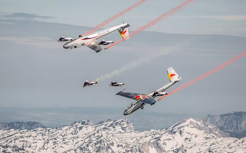 Skydivers ’fly’ in formation with gliders in daring stunt over the Alps. At speeds of up to 120mph the skydivers, wearing specially-designed aerodynamic winged suits, fly alongside the planes.