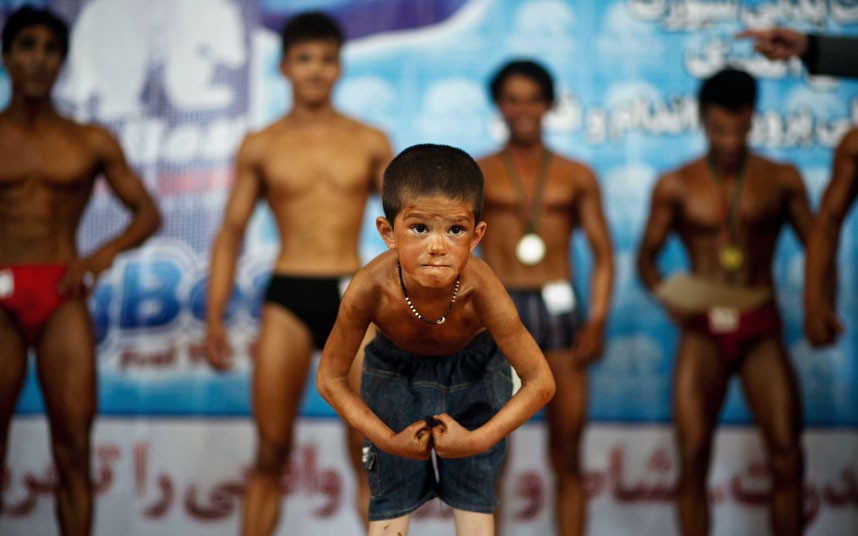 Những hình ảnh ấn tượng trong tuần ảnh 8 A young boy flexes his muscles during a regional bodybuilding competition in Kabul, Afghanistan
