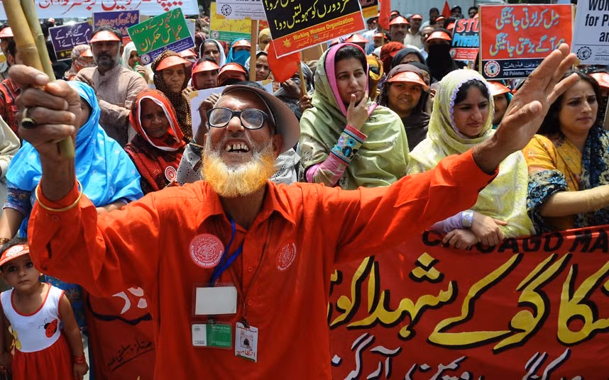 Pakistani labour union workers carry placards as they shout slogans during a May Day rally in Lahore
