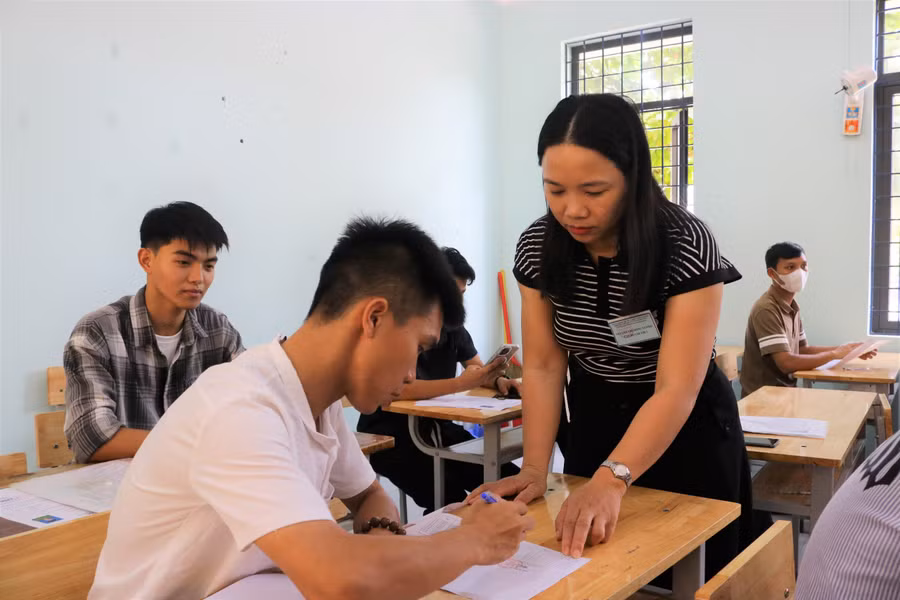 Thí sinh ký vào giấy dự thi và điều chỉnh thông tin.