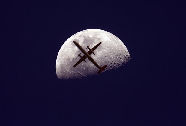 Fly me to the moon: Christopher Tomas spent months planning this photograph of a passenger jet flying past the moon that he took on the Blackbutt range in Queensland, Australia. 