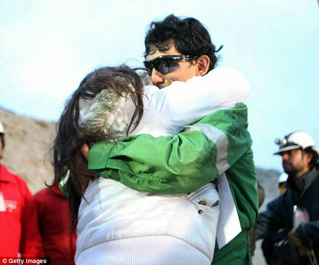 Claudio Yanez, 34, is hugged by a relative as he becomes the eighth miner to exit the rescue capsule Read more: http://www.dailymail.co.uk/news/article-1320045/CHILEAN-MINERS-RESCUE-Back-dead-69-days-trapped-underground.html#ixzz12HuZhynp
