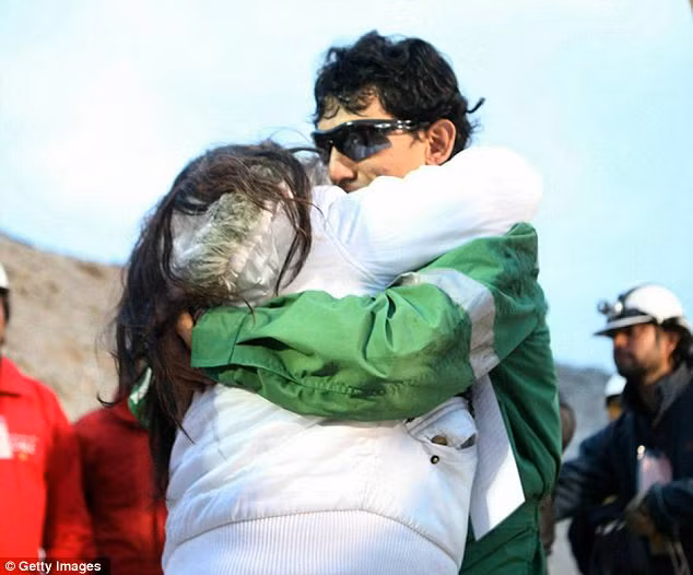 Claudio Yanez, 34, is hugged by a relative as he becomes the eighth miner to exit the rescue capsule Read more: http://www.dailymail.co.uk/news/article-1320045/CHILEAN-MINERS-RESCUE-Back-dead-69-days-trapped-underground.html#ixzz12HuZhynp