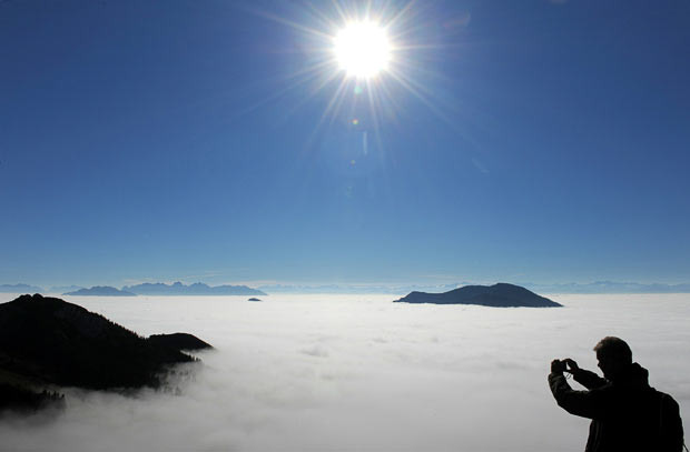 Những hình ảnh ấn tượng trong tuần ảnh 4 A hiker takes a picture of the foggy Alps as he stands above the clouds on a visitor’s platform near the top of the Wendelstein (1,838 metres high) in the Mangfall mountains, the Bavarian foothills of the Alps, near the village Bayrischzell, southern Germany