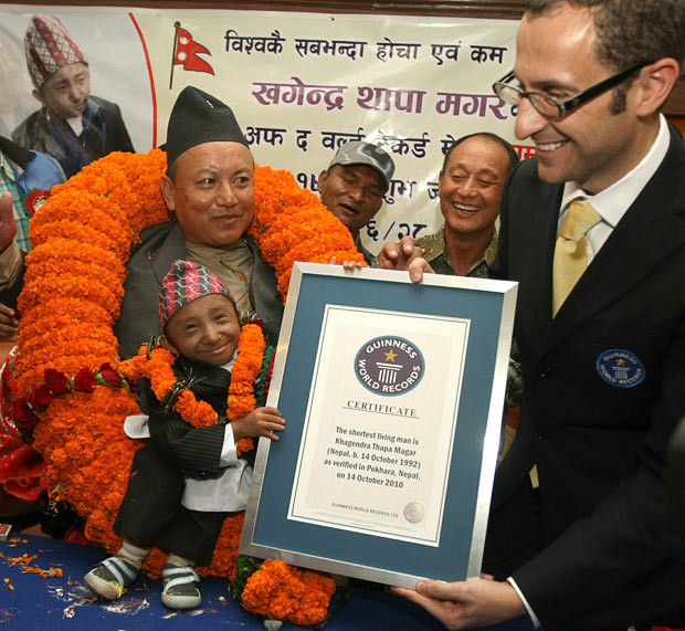 Những hình ảnh ấn tượng trong tuần ảnh 8 A Guinness World Records official hands over a certificate to the world’s shortest man, Khagendra Thapa Magar in Pokhara, some 200 kms west of Kathmandu. The Nepalese teenager whose tiny stature has made him a celebrity in his homeland entered the record books as the world’s shortest man at 67.08 cm or 26.4 inches according to new measurements by Guinness, as he celebrated his 18th birthday. He takes the title from Colombia’s Edward Niño Hernandez, whose record stood for just five weeks. Khagendra measures 2 ft 2.41 in (67.08 cm) tall, nearly 2 inches shorter than his predecessor