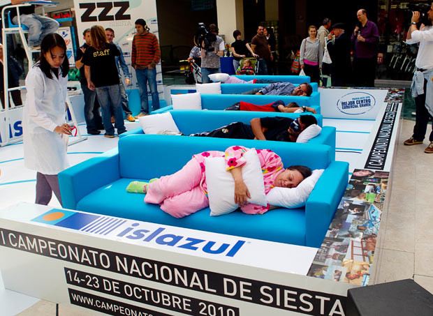 Những hình ảnh ấn tượng trong tuần ảnh 15 A doctor checks as people sleep a siesta during the first Siesta Championship in Madrid. The participants of the siesta contest win points for the first person to fall asleep, the loudest snorer, best original sleeping position and best dressed sleeper