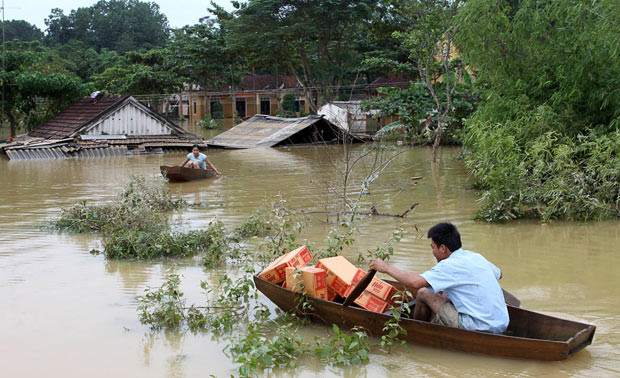 A man paddles a boat while transporting relief supplies at an isolated village during a flood in Huong Khe district, in Vietnam’s central province of Ha Tinh