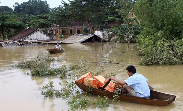 A man paddles a boat while transporting relief supplies at an isolated village during a flood in Huong Khe district, in Vietnam’s central province of Ha Tinh