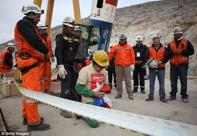 Thank goodness: The oldest rescued miner Claudio Mario Gomez, 59, kneels as he becomes the ninth to exit the rescue capsule Read more: http://www.dailymail.co.uk/news/article-1320045/CHILEAN-MINERS-RESCUE-Back-dead-69-days-trapped-underground.html#ixzz12HvyoyRi