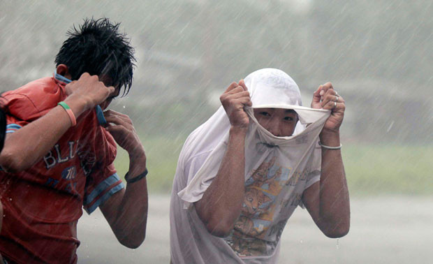 People walk through Typhoon Megi’s strong winds and rain in Isabela province, northern Philippines