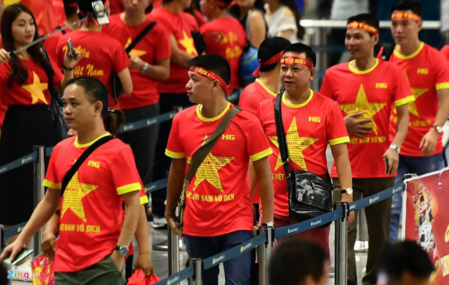 Hàng trăm CĐV với trang phục áo cờ đỏ sao vàng, đeo băng rôn, khẩu hiệu làm thủ tục lên đường sang Jakarta. Ảnh: zing.vn