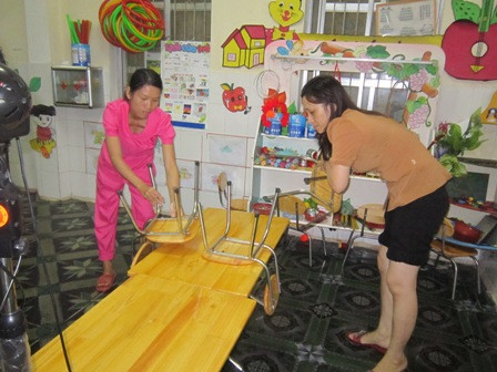 Giáo viên thu dọn đồ dùng học tập của học sinh tránh ngập lụt.