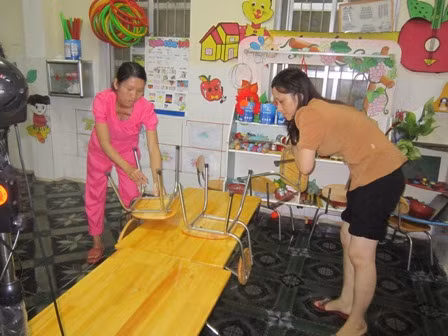 Giáo viên thu dọn đồ dùng học tập của học sinh tránh ngập lụt.