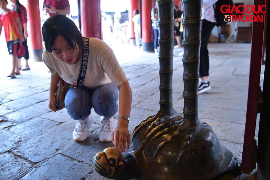 Các sĩ tử được thoải mái sờ đầu rùa đồng cõng hạc đặt ở ngoài chính điện