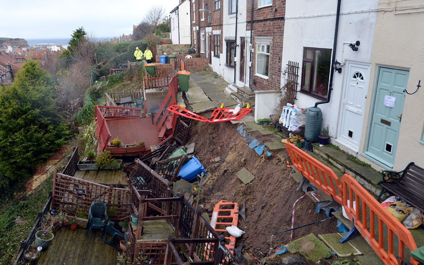 A row of terraced houses high above Whitby harbour are collapsing down the cliff following torrential rainfall. The council is making plans for the immediate demolition of the houses.
