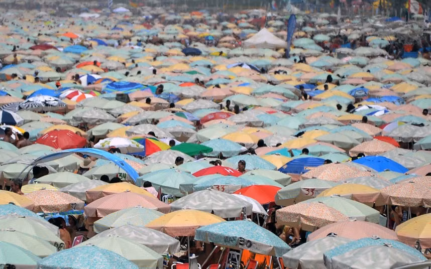 People shelter from the sun on Ipanema beach in Rio de Janeiro. The city reported a record high of 43.2C (109.7F), the highest temperature since 1915.