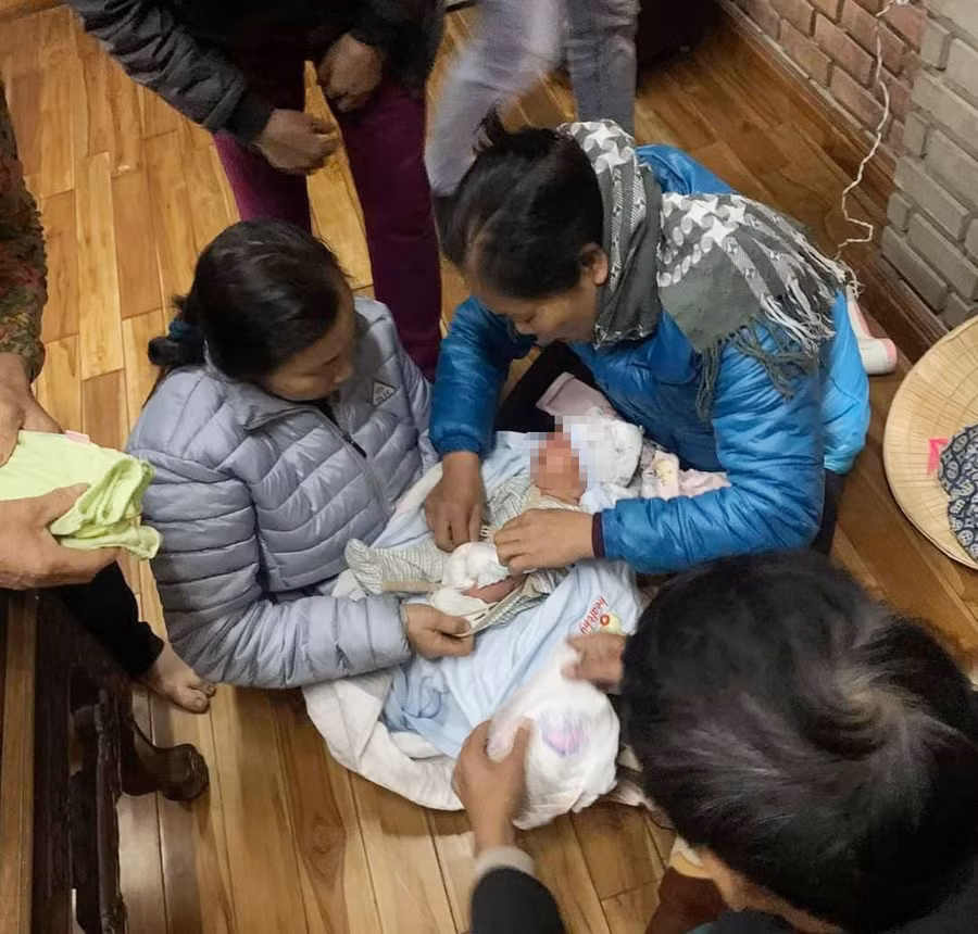 Sau khi được phát hiện, cháu bé được người dân thay quần áo, ủ ấm