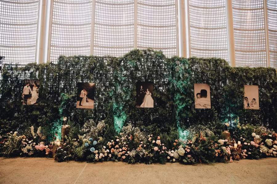 Sảnh dẫn vào hội trường tiệc được tô điểm bởi ảnh cưới của đôi uyên ương và hoa tươi.