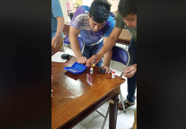 Cư dân chung cư HH Linh Đàm tự lấy mẫu nước để test nhanh nồng độ PH và clo.( ảnh cắt clip)