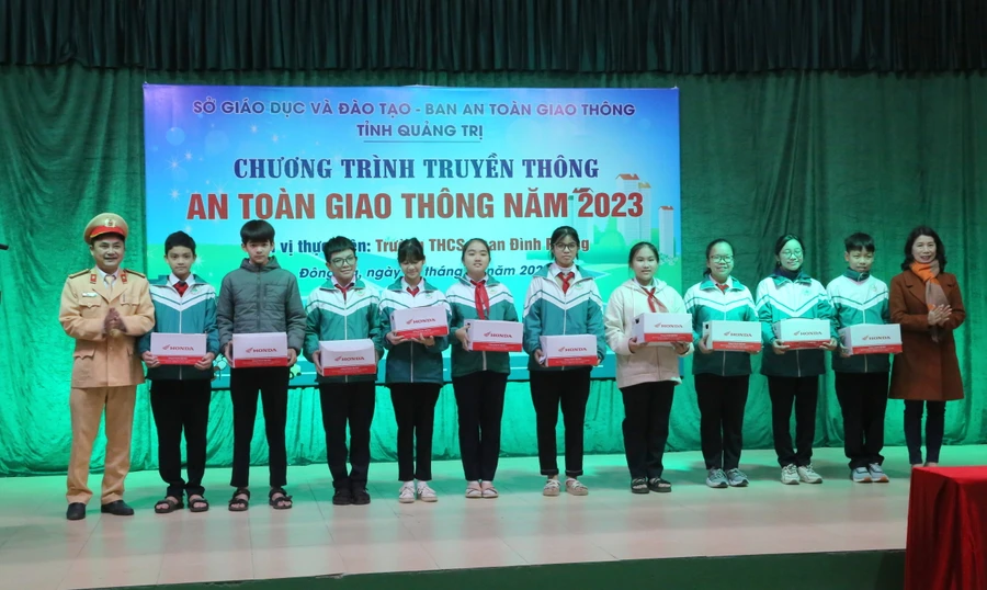 Tặng mũ bảo hiểm cho học sinh.