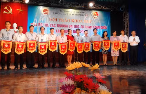 Thứ trưởng bộ GD&ĐT Nguyễn Vinh Hiển (ngoài cùng bên phải) trao cờ lưu niệm cho các trường ĐH tham gia hội thảo khoa học